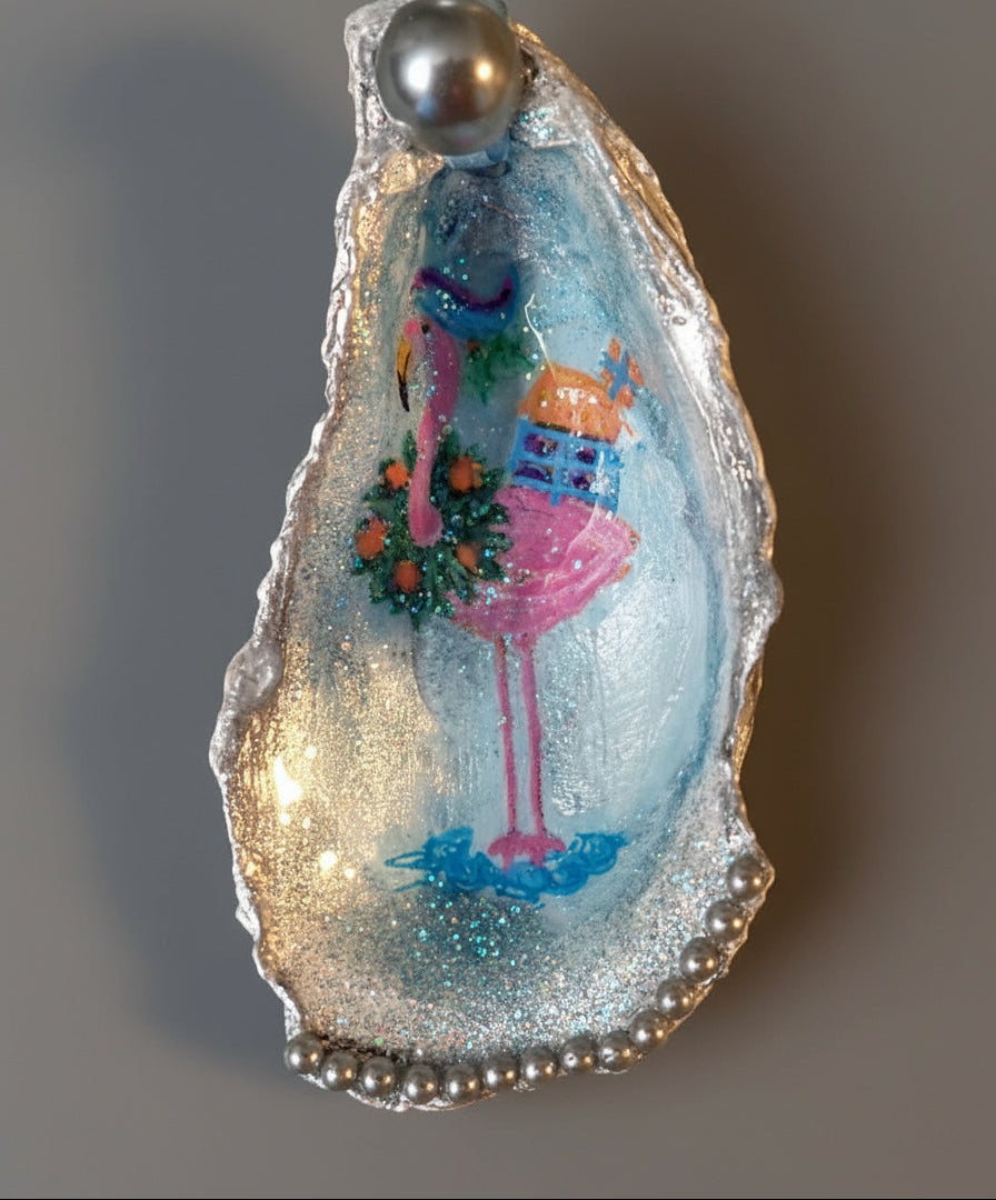 Decorative oyster shell with a pink flamingo and gift box design on a gray background