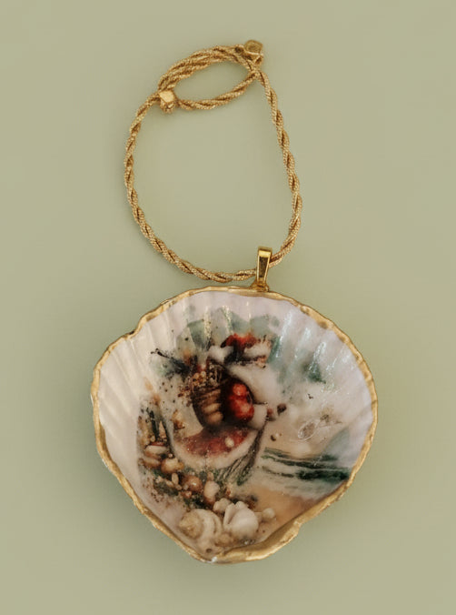 Decorative shell ornament with a Christmas scene on beach with sand and mini-shells 